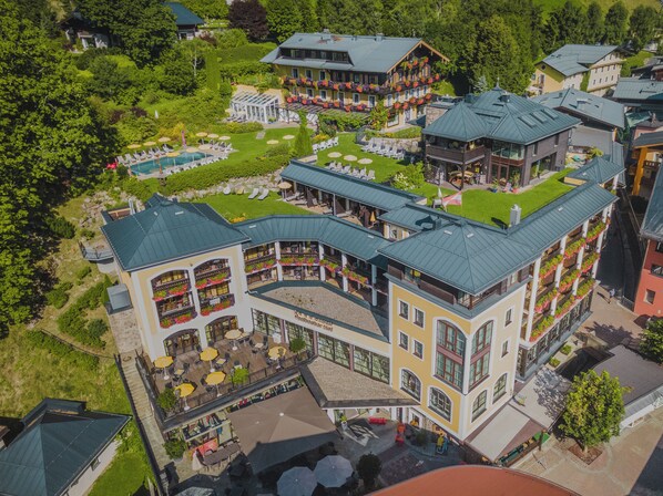 Un hôtel à plusieurs étages doté d’espaces de détente en plein air et d’une piscine.