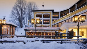 A hotel with multiple floors, large windows, and outdoor seating areas.