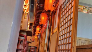 A corridor with traditional lanterns, wooden doors, and a tiled floor. - Oasis Hotel Kuwait (Kuwait City)
