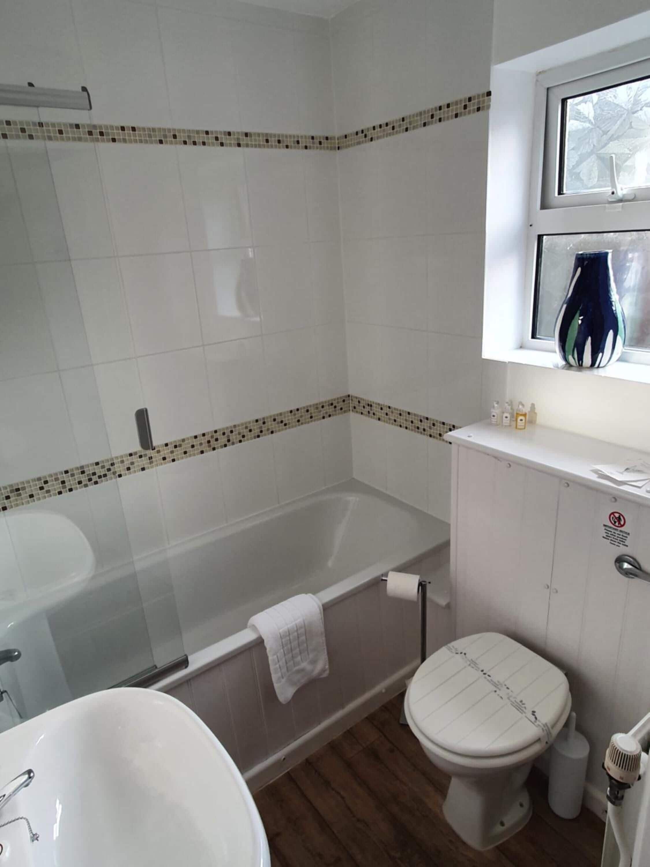 A bathroom with a bathtub, toilet, and sink.