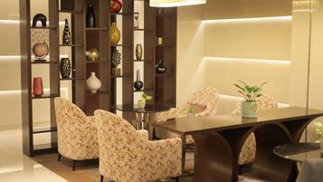 A modern interior with a dining area, sofas, and a decorative bookshelf.