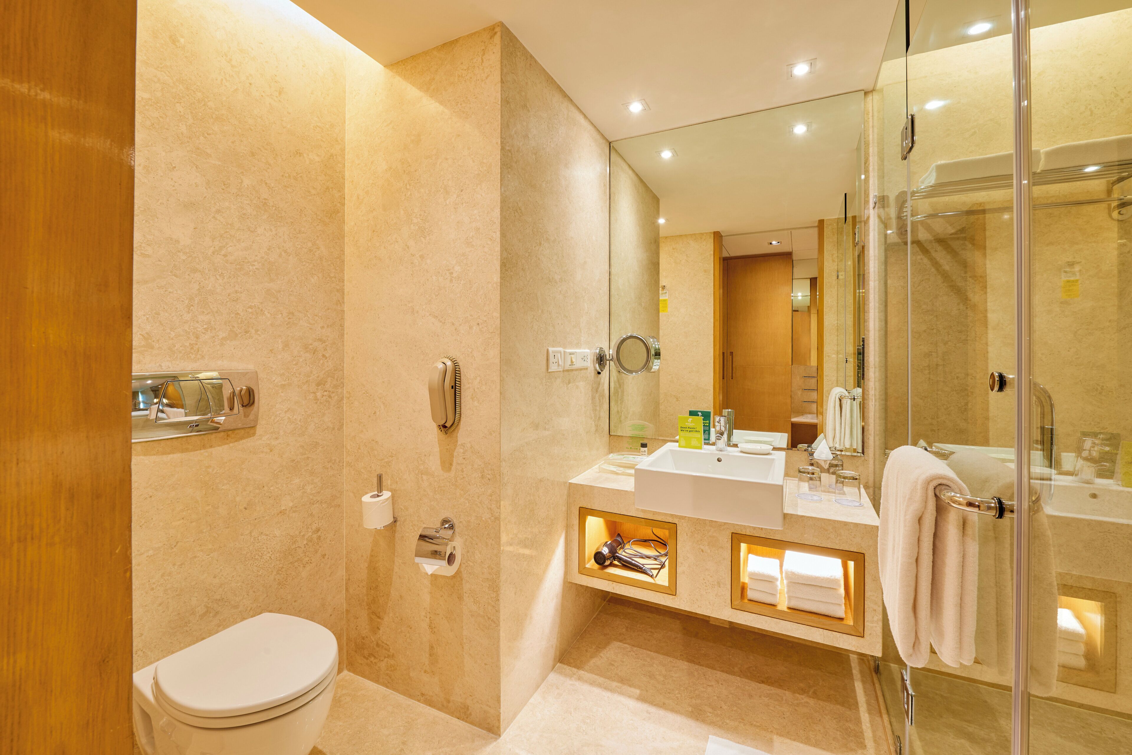 Un baño moderno con inodoro, lavabo y zona de ducha.