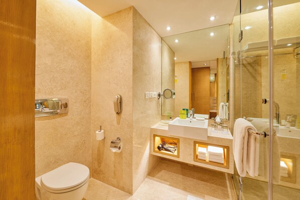 A modern bathroom with a toilet, sink, and shower area. - Holiday Inn Mumbai International Airport by IHG (Mumbai)