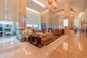 A modern hotel lobby with a central island, seating area, and a reception desk. - Holiday Inn Mumbai International Airport by IHG (Mumbai)