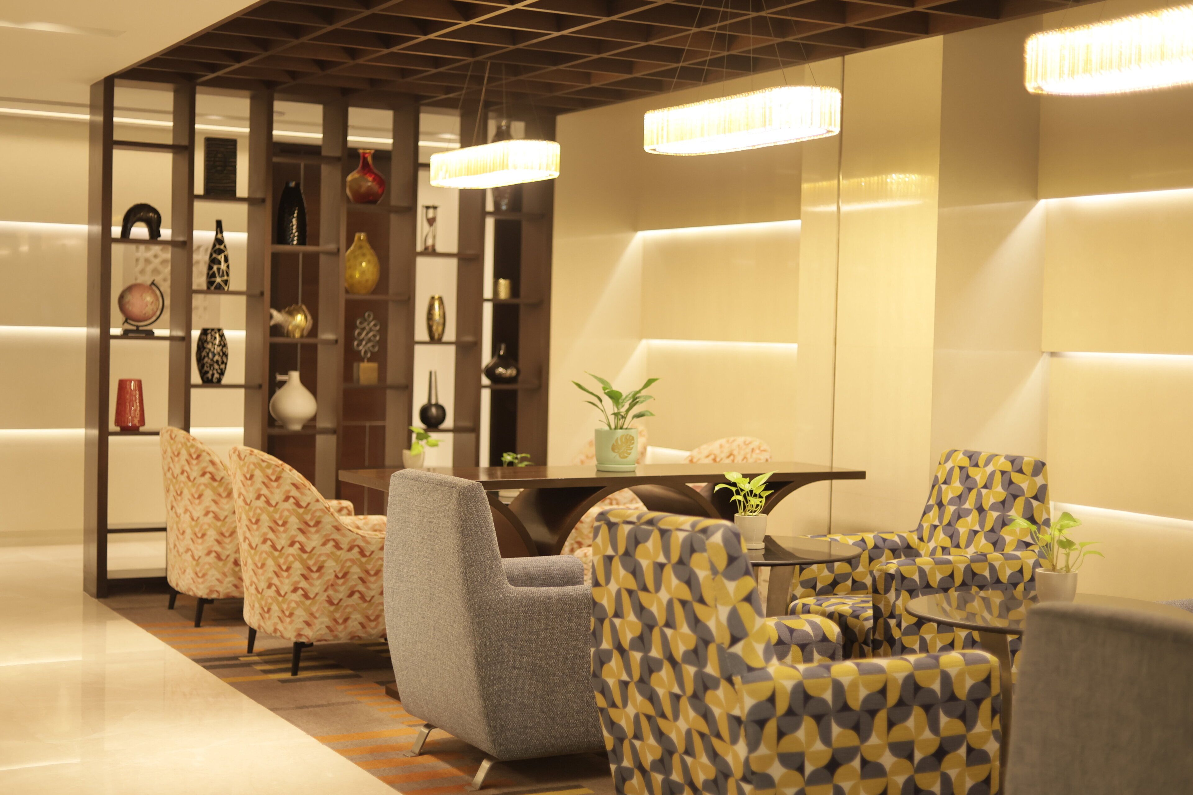 A modern interior with a seating area, a table, and decorative items on shelves.