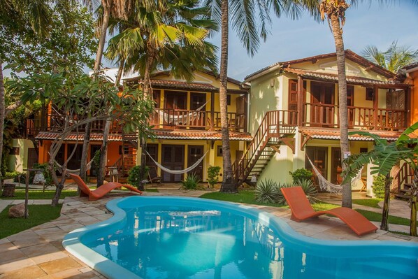 Una piscina al aire libre, sillones reclinables de piscina