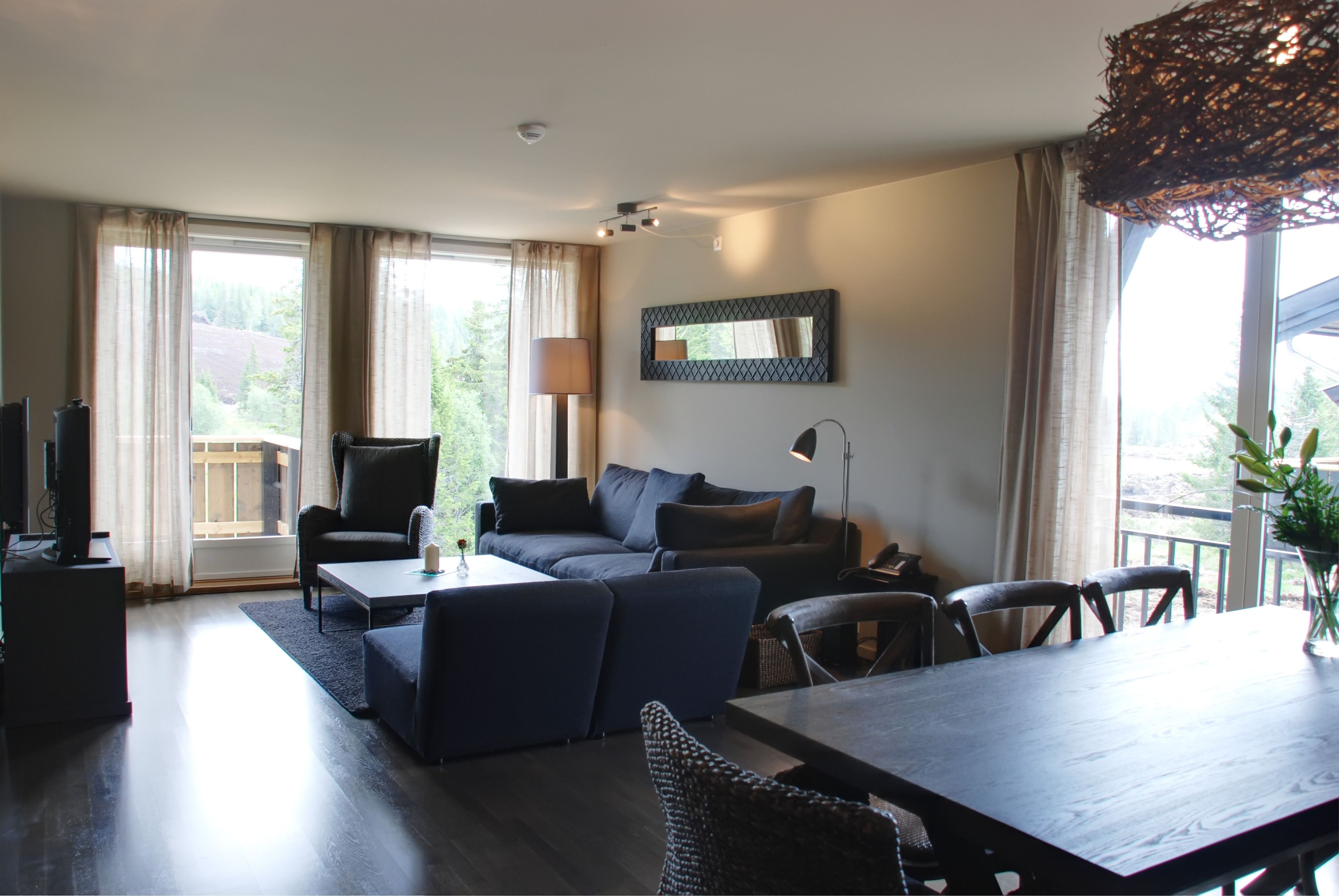 A modern living room with a sofa, coffee table, and dining table.