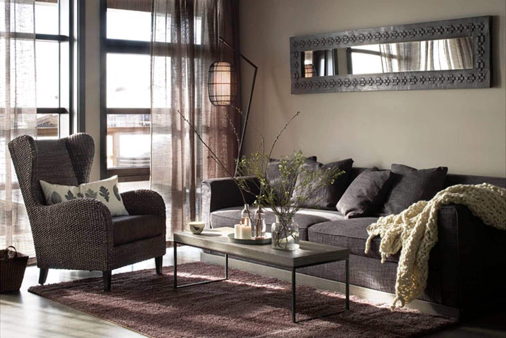 A living room with a sofa, armchair, coffee table, and decorative items.