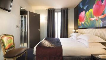 Una habitación de hotel con una cama, una silla, un televisor y un cuadro de flores.