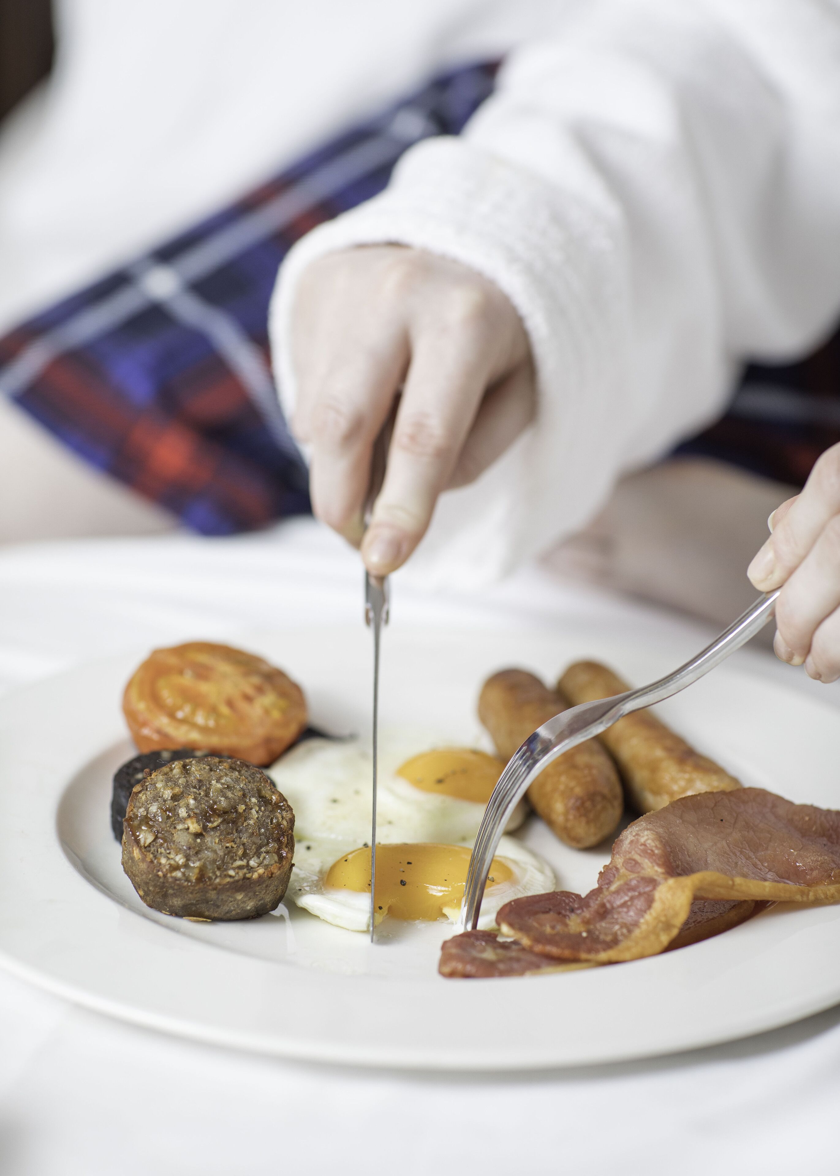 Ein Frühstücksteller mit Eiern, Würstchen und Speck.