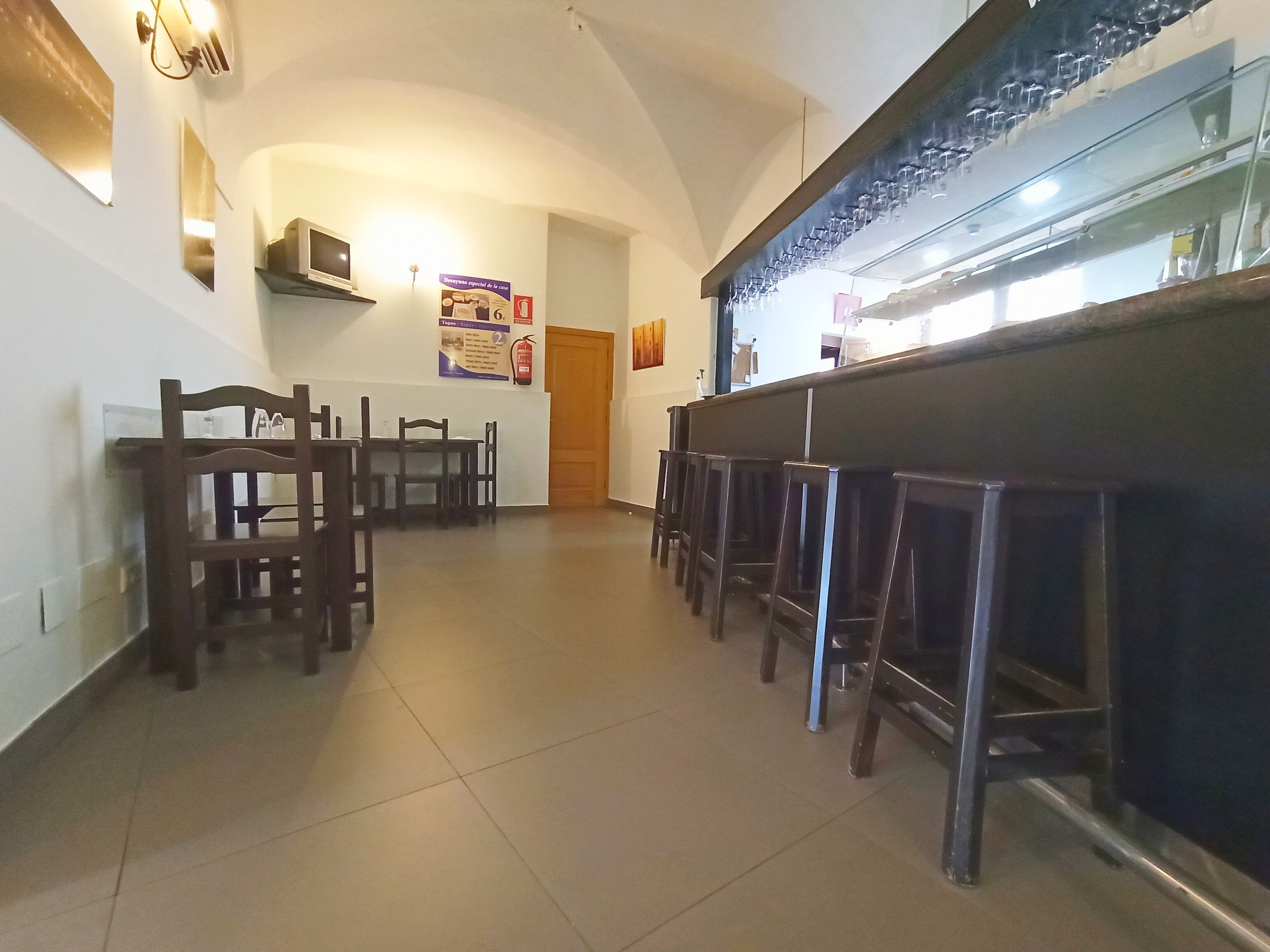 A bar area with stools, a counter, and a tiled floor.