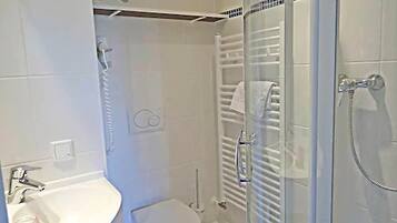 Ein Badezimmer mit Toilette, Waschbecken und Duschbereich.