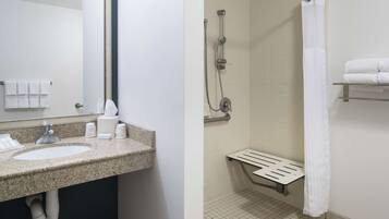 A bathroom with two sinks, a shower, and a towel rack.