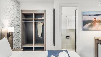 Une chambre d’hôtel avec un lit, une armoire, une douche et un tableau représentant un pont.