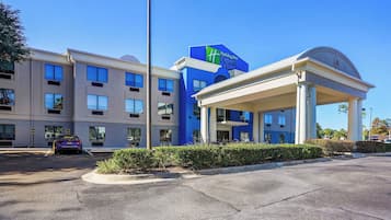 A Holiday Inn Express building with a modern design, including a covered entrance and a parking lot.