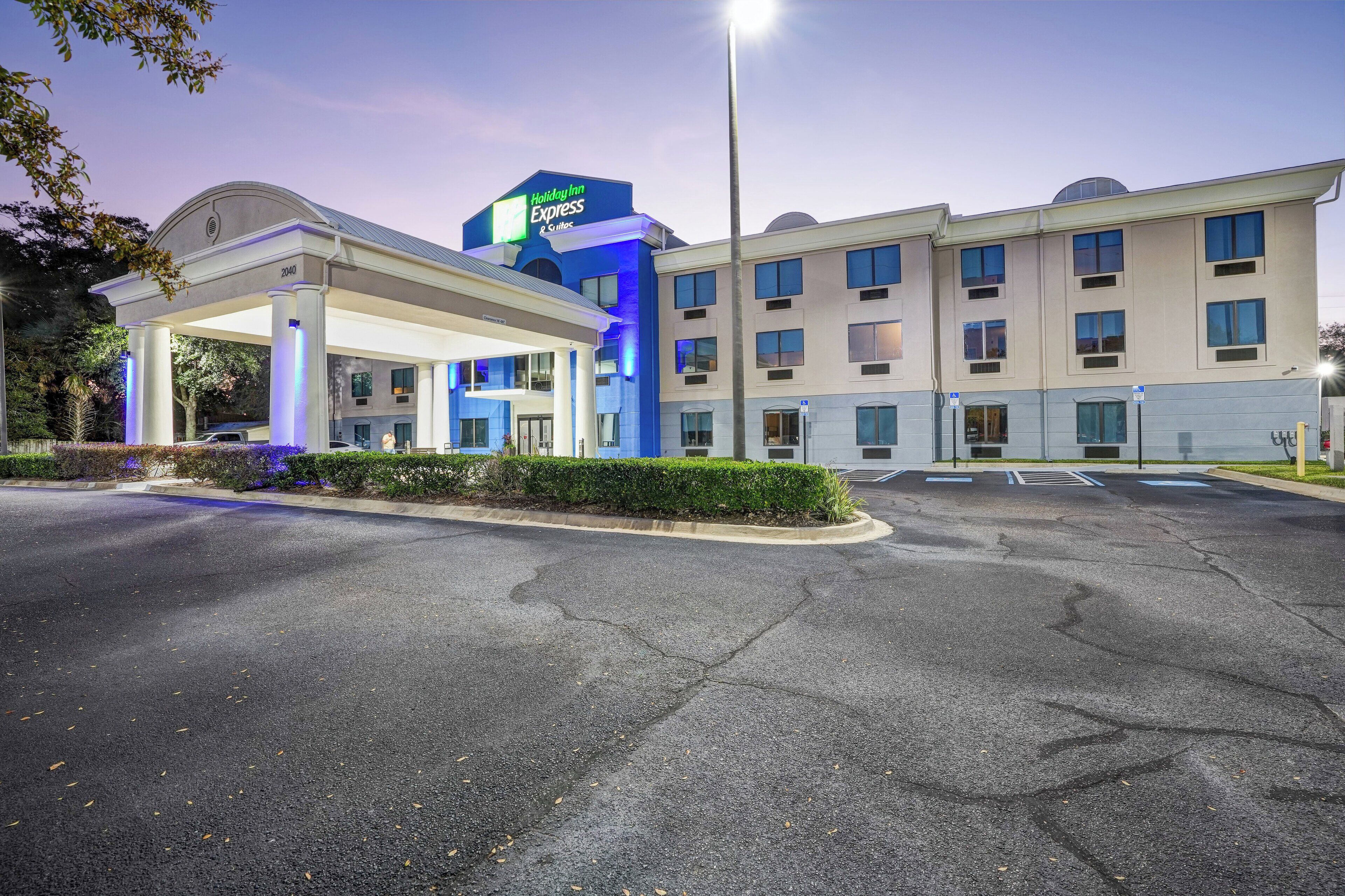 Un hotel Holiday Inn Express con una stazione di servizio, diversi piani e un parcheggio.