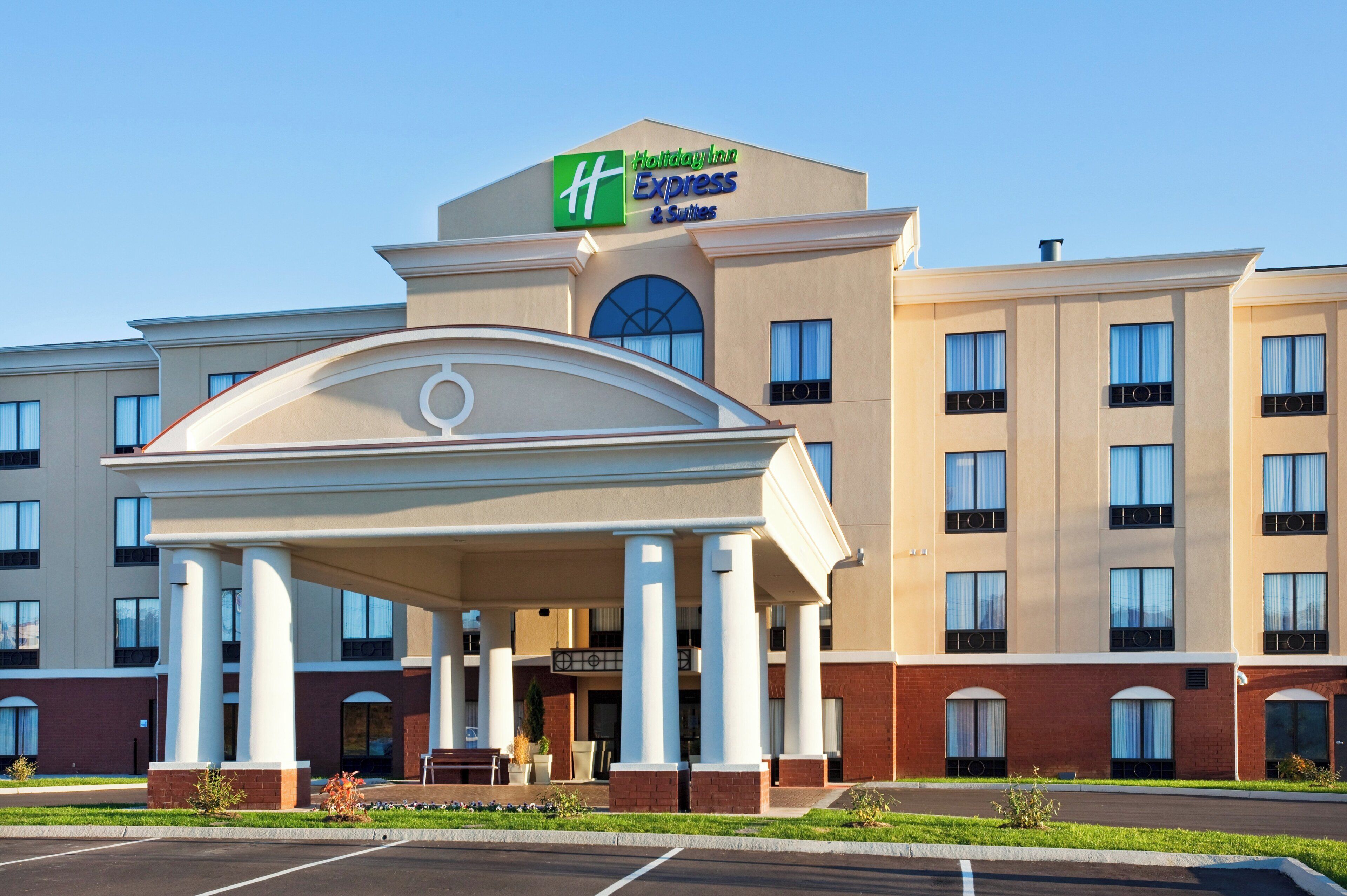 A Holiday Inn Express hotel with a central entrance pavilion, multiple windows, and a parking lot.