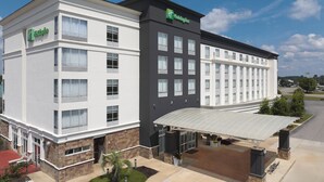 Et Holiday Inn Express hotel med moderne design, karakteriseret ved et fladt tag, en overdækket indgang og en anlagt forhave.