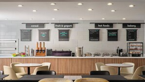 En moderne café med en disk der viser morgenmadstilbud, siddepladser og et rent, minimalistisk design.