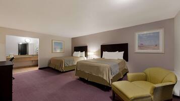 A hotel room with two beds, a chair, a desk, and a mirror.