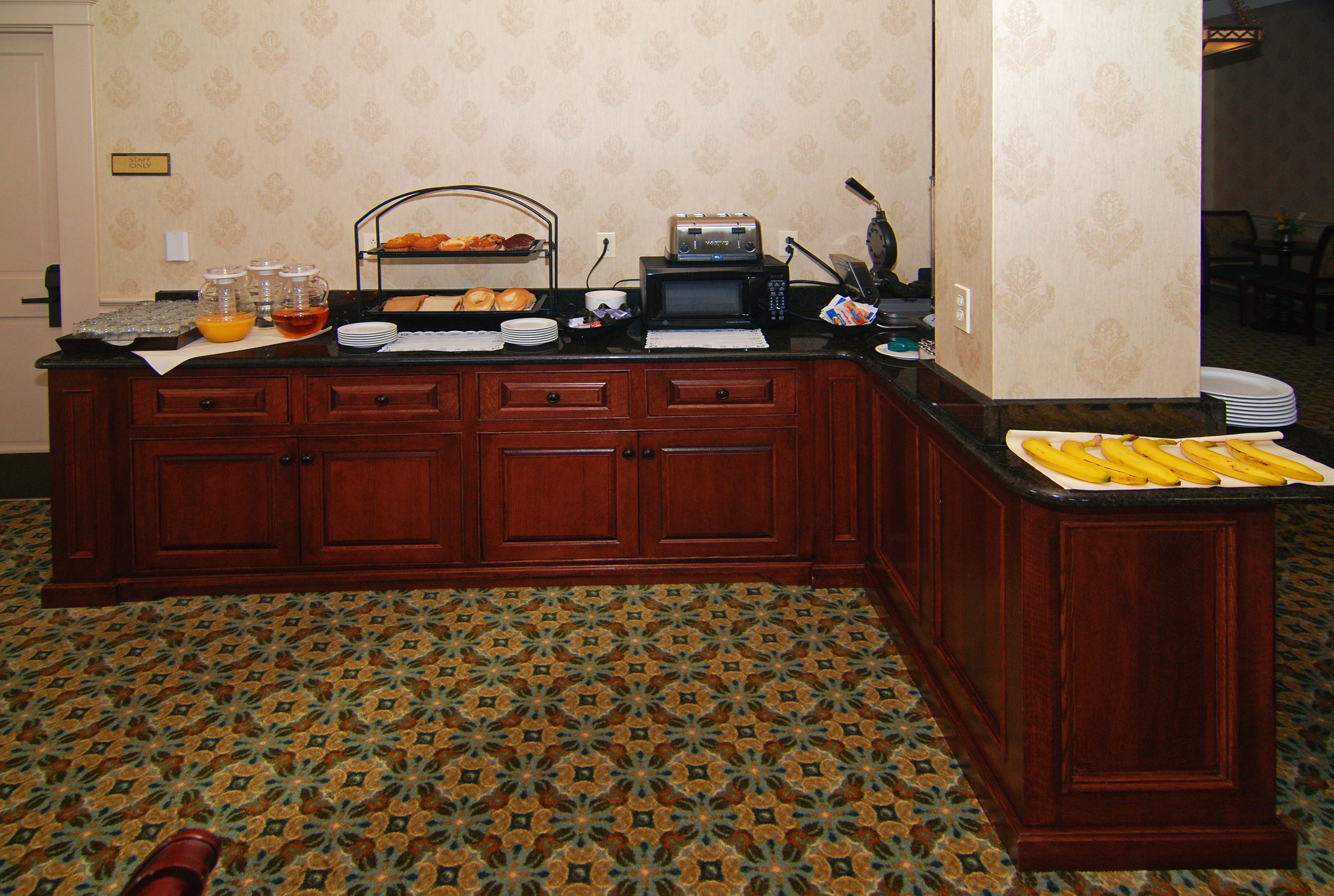 A kitchen area with a microwave, toaster, and a fruit tray.