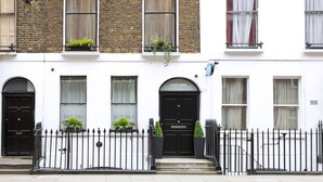 A building with a black door labeled "City Inn," a white facade, and a black iron fence. - City Inn Russell Square (London)