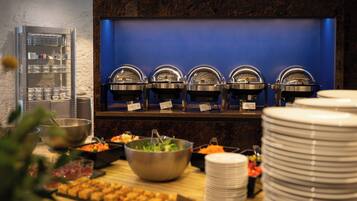 Ein reichhaltiges Buffet mit mehreren Servierstationen, einer Salatschüssel und einer Auswahl an Speisen.