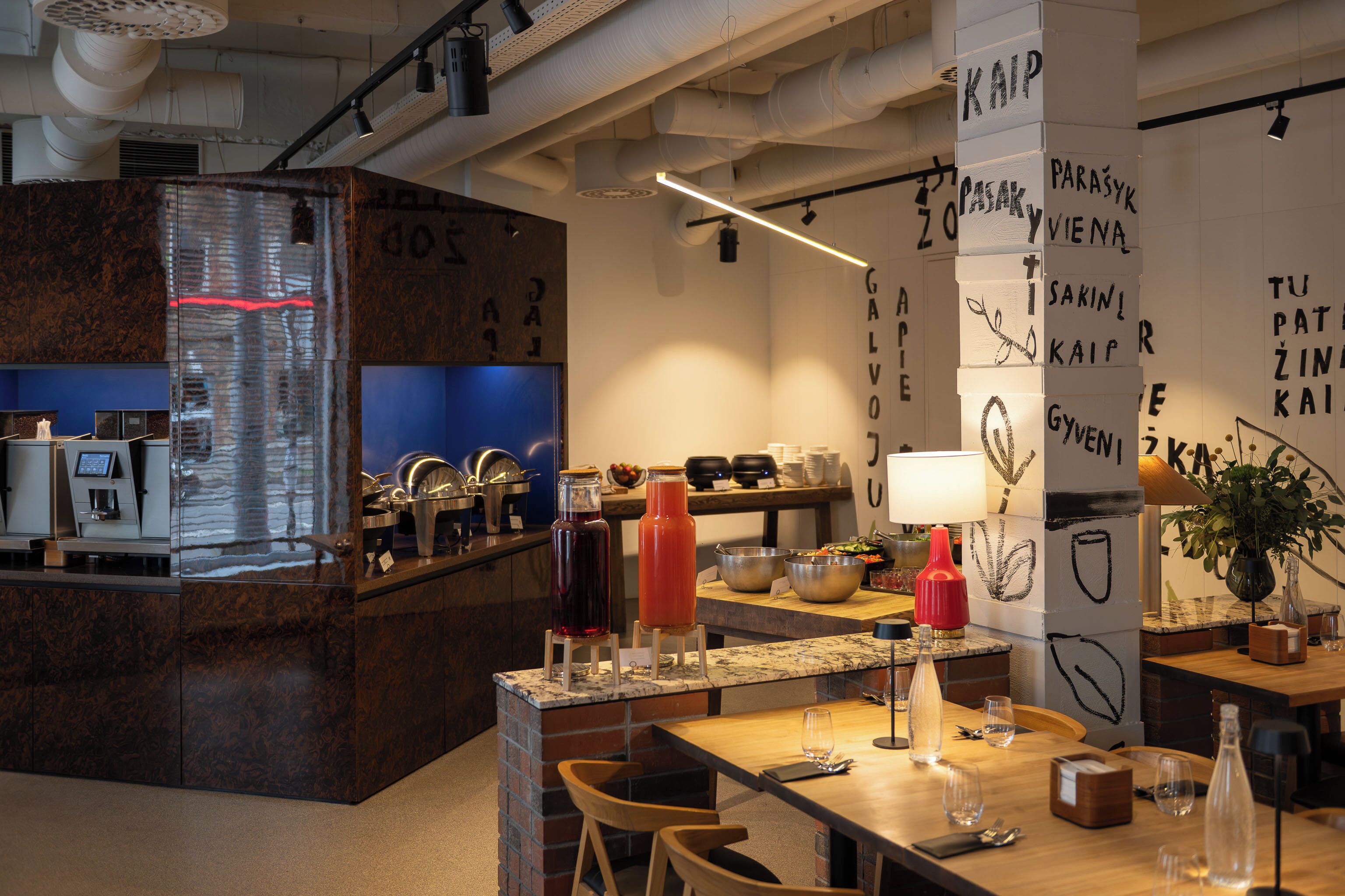 Una cocina moderna con una isla central, zona de bar y un espacio con sillas.