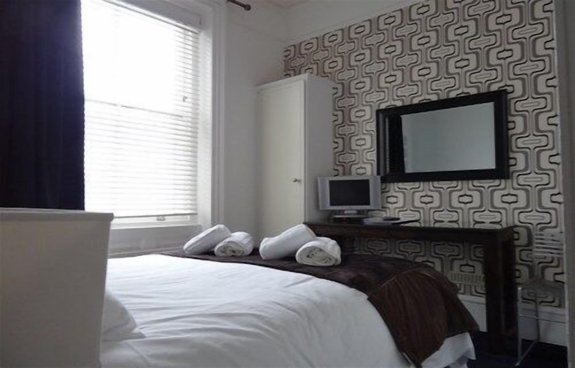 Una camera d'albergo con un letto, una televisione e un armadio.