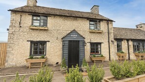 A stone building with a black door labeled "DUKE" and a date "1753". - Duke of Marlborough Hotel (Woodstock)