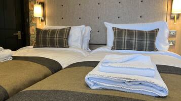 Ein Hotelzimmer mit einem großen Bett, zwei Nachttischen und einem Kopfteil mit Wandleuchten.