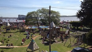 A park with playgrounds, picnic areas, and a view of a body of water.