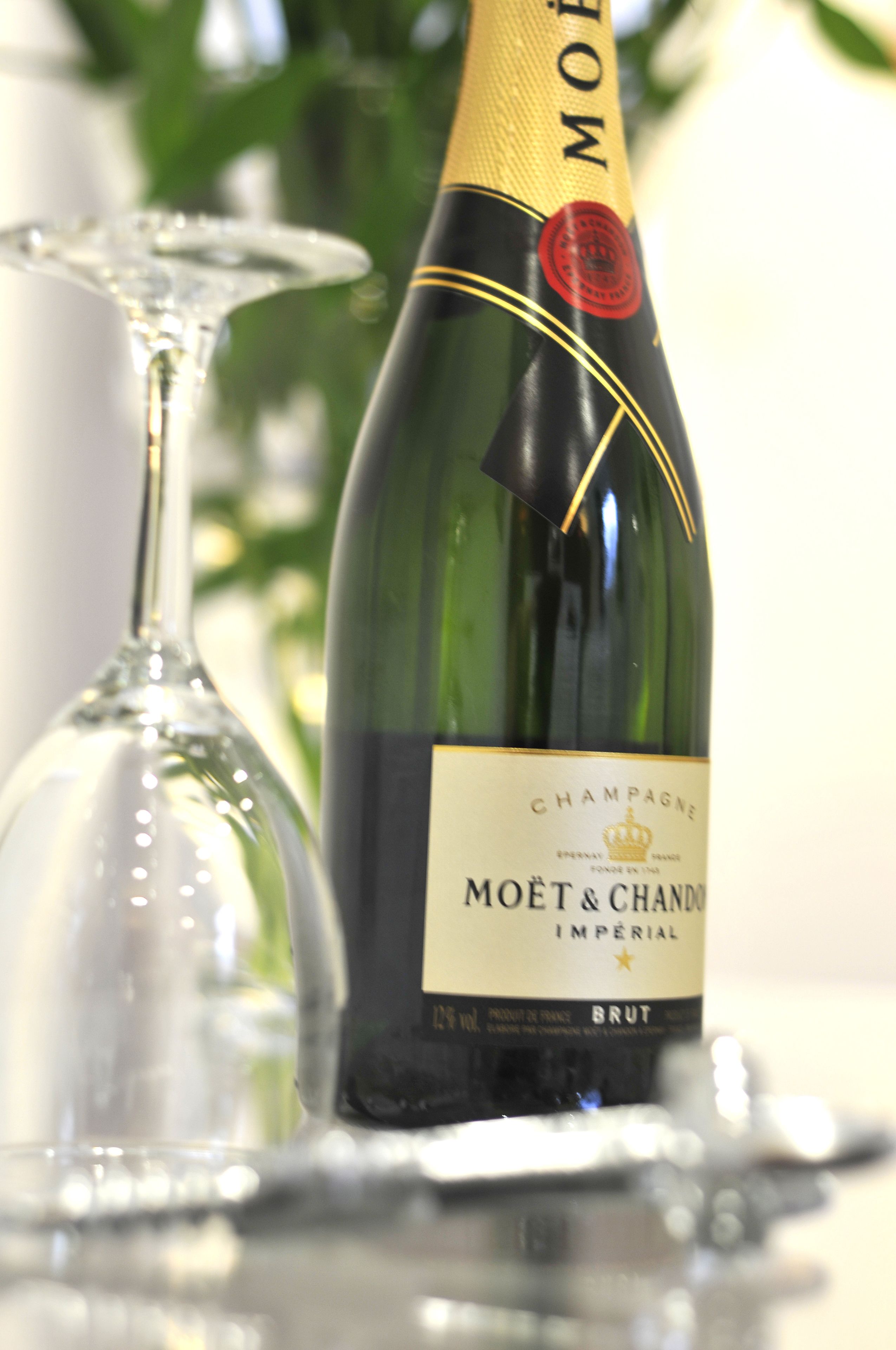 Una botella de champán Moët & Chandon Imperial y una copa de cristal.