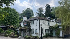 Un bâtiment blanc avec une enseigne indiquant « The Waterman's Arms » et un panneau indiquant « Parking de Waterside Arms ».