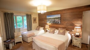 Une chambre d’hôtel avec deux lits, un mur en bois, une fenêtre avec des rideaux, une chaise, une table et une lampe.