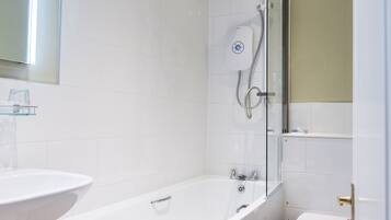 A modern bathroom with a bathtub, a glass shower enclosure, and a toilet.