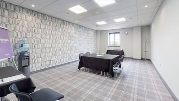 A conference room with a checkered floor, a table with a black tablecloth, and a water dispenser.