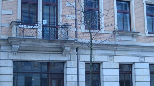 Un edificio de varios pisos con una tienda en la planta baja.