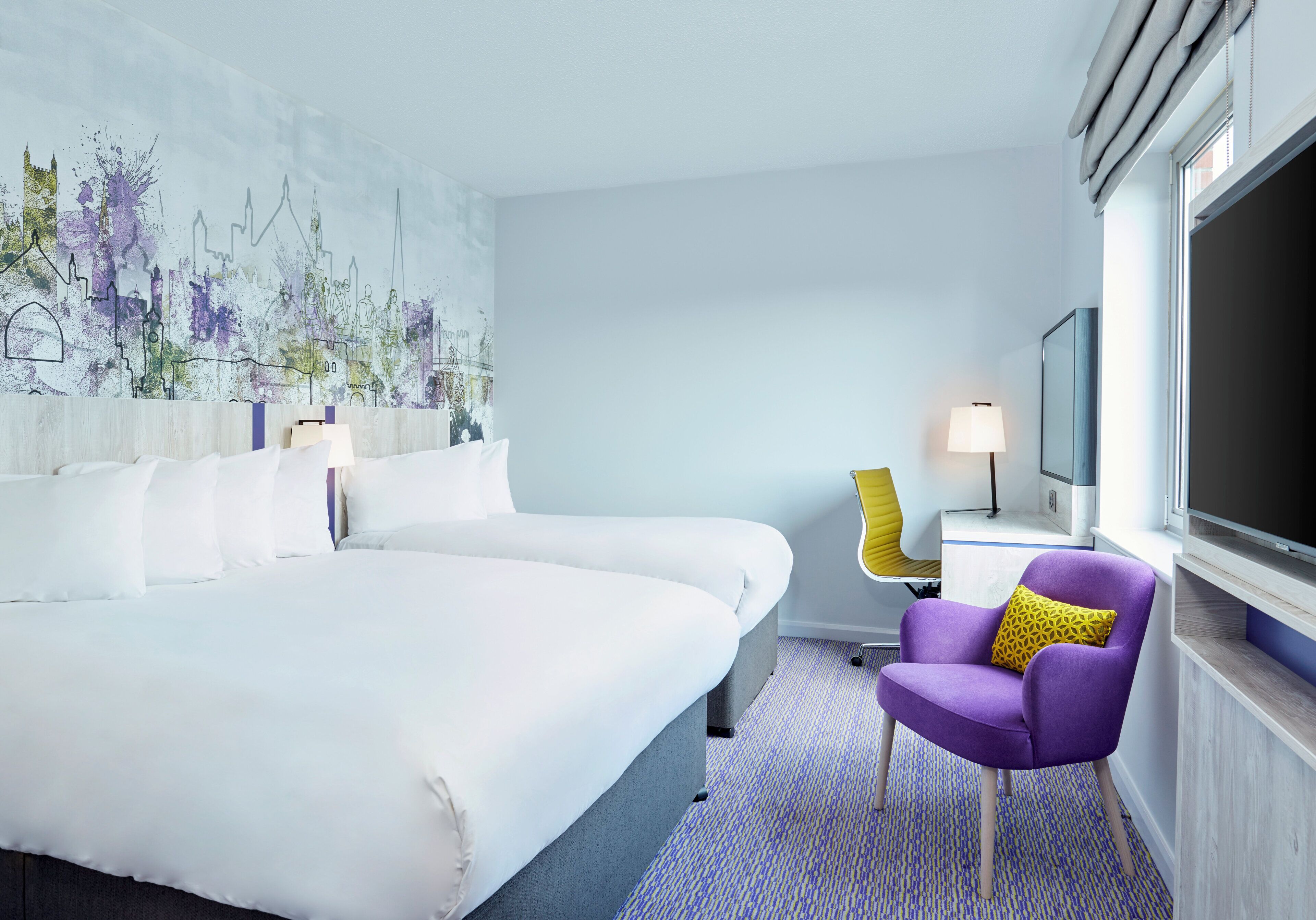 Una habitación de hotel con una cama grande, un sillón púrpura, un televisor y un mural con vistas a la ciudad.