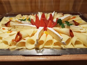 A buffet tray with various food items, including sliced meats, cheeses, and garnishes. - Hotel Reitlwirt (Brixen im Thale)