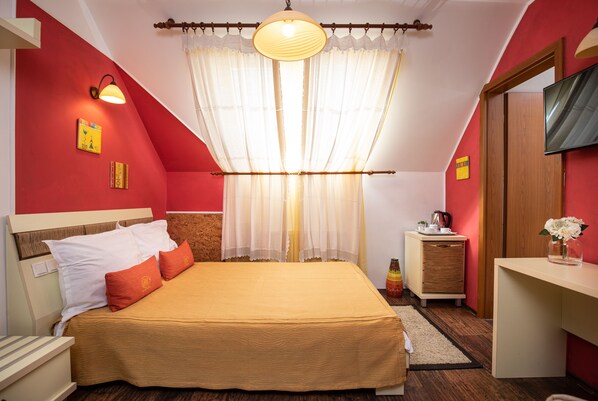 Un dormitorio con cama, mesita de noche y escritorio con silla.
