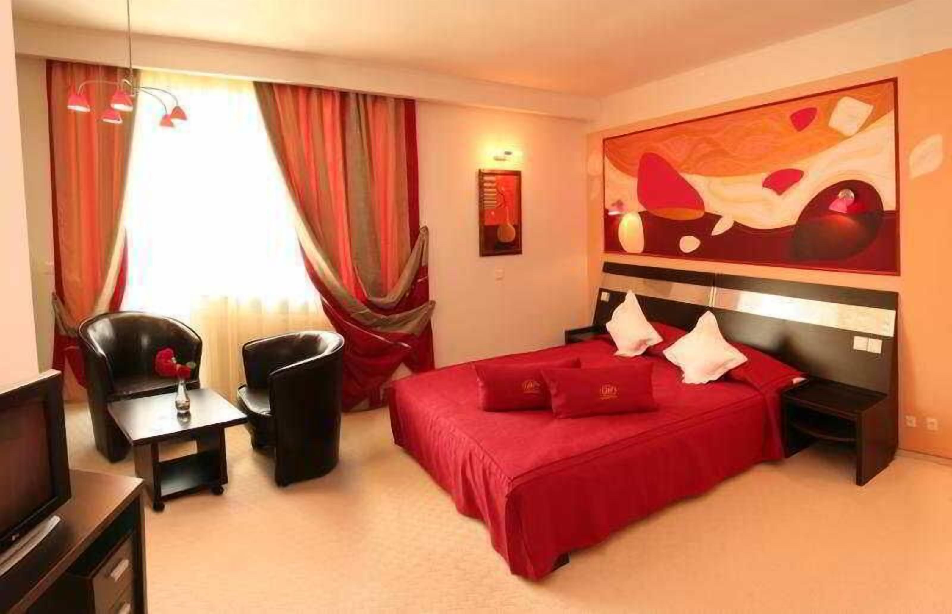 Una habitación de hotel con cama, televisión, escritorio y silla.