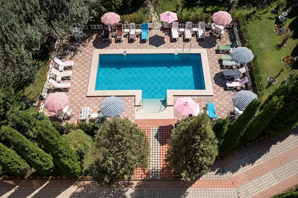 Una piscina al aire libre de temporada, sombrillas