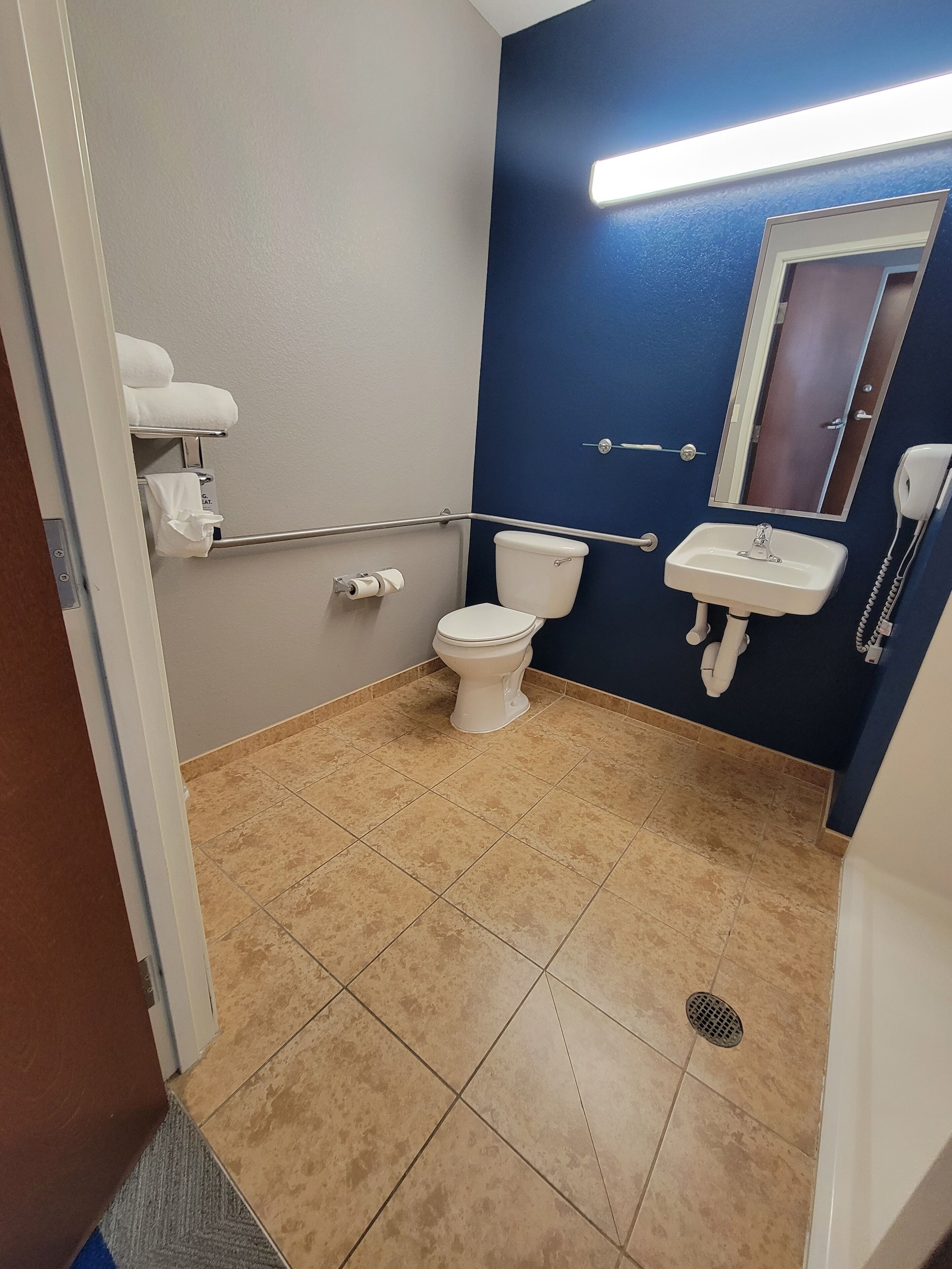 A bathroom with a toilet, sink, and mirror.