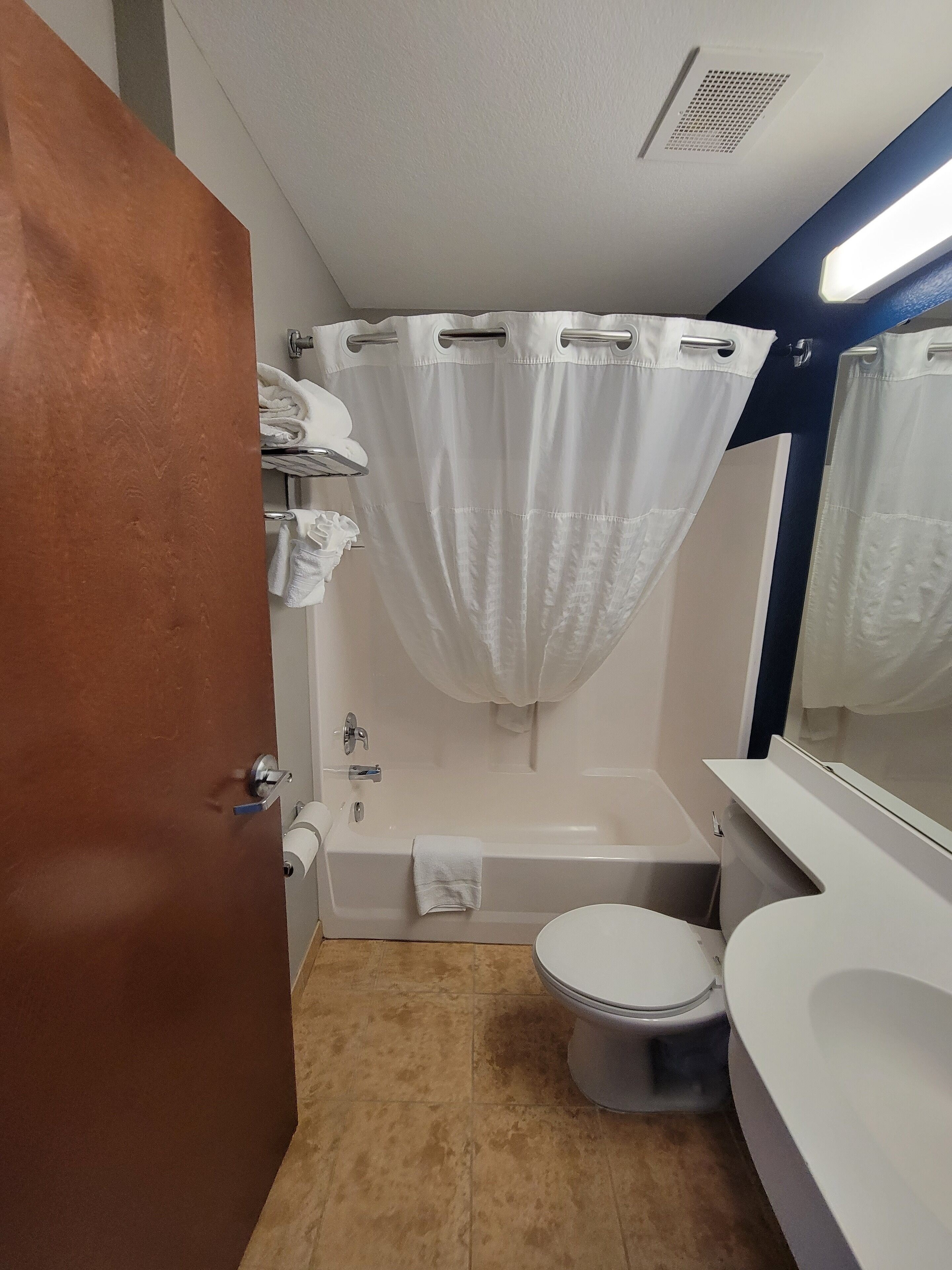 A bathroom with a bathtub, toilet, and a sink.