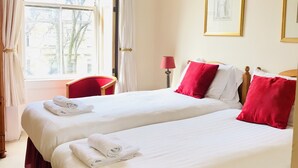 A hotel room with two beds, a window with curtains, a chair, and a lamp. - The Georgian House Hotel (Glasgow)