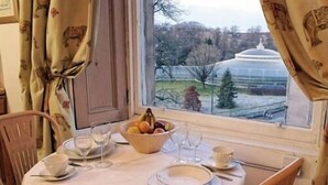 A dining table set for two with a bowl of fruit, plates, and cutlery. - The Georgian House Hotel (Glasgow)