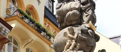 A detailed stone sculpture with figures, a Star of David, and flags on a building facade.