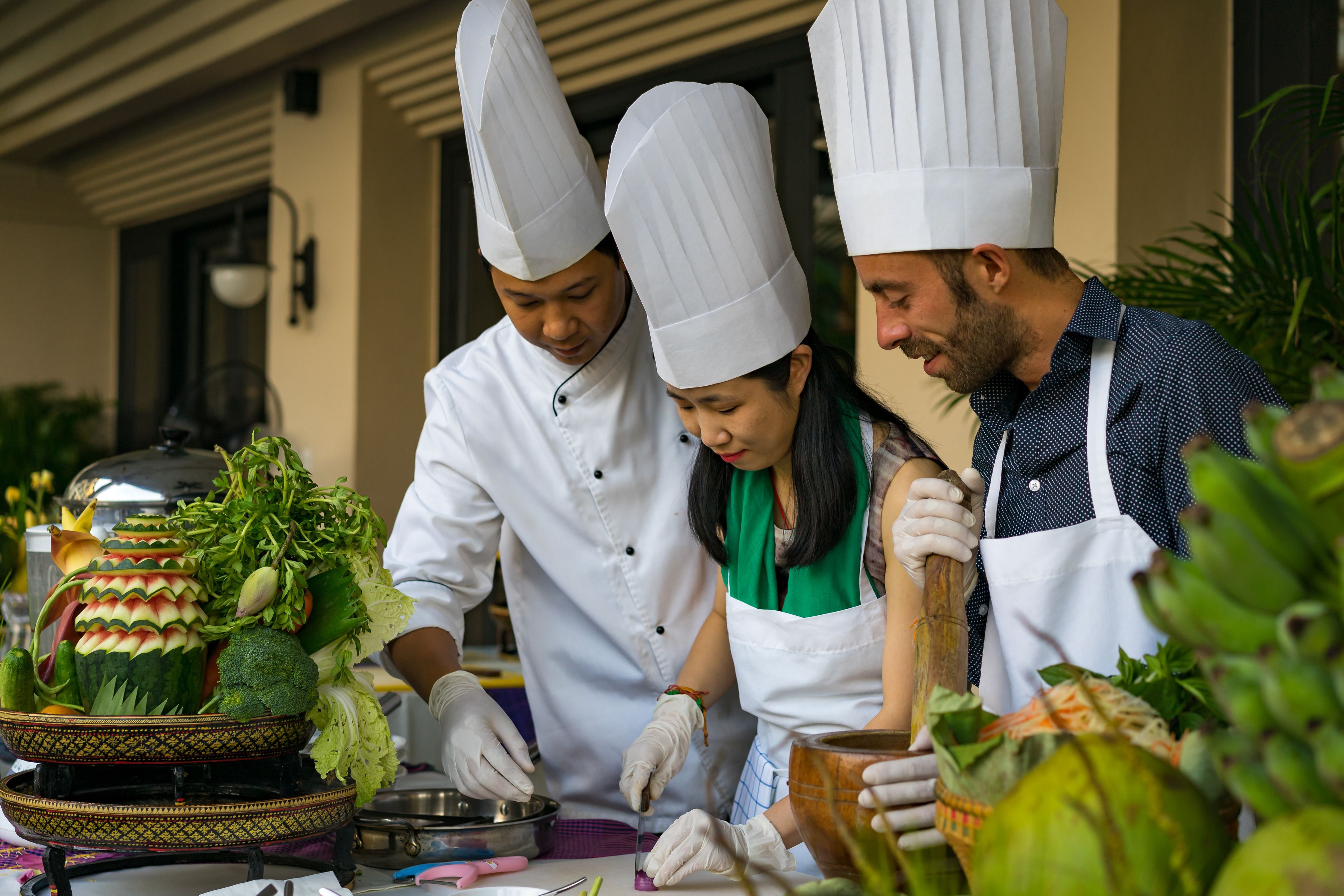 Jefes de cocina preparando alimentos en una cocina profesional.
