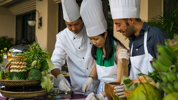 Jefes de cocina preparando alimentos en una cocina profesional.